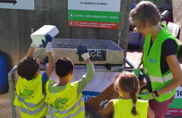 Juf Karen samen met kleuters op het recyclagepark